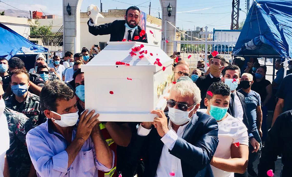 Sahar Fares’s fiancé, Gilbert Karaan, waves a handkerchief over Fares’s coffin at her funeral on Thursday, Aug. 4, 2020. (via The New York Times)