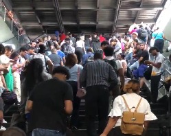 Ciudadanos se refugian de la lluvia en la estación Freddy Beras Goico